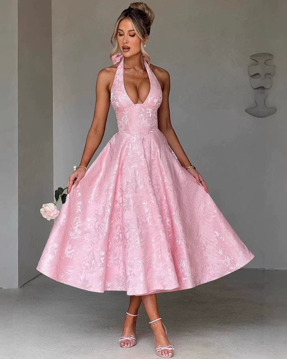 Woman wearing a pink lace dress against a gray background