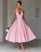 Woman wearing a pink lace dress against a gray background