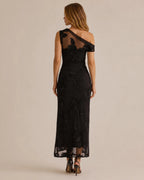 A woman modeling a black off-the-shoulder lace maxi dress from the back, shown against a plain beige studio background.