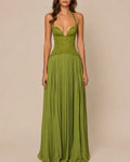 A woman modeling a floor-length olive green gown with a lace corset-style bodice, thin shoulder straps, and a flowing pleated skirt against a plain beige studio background.