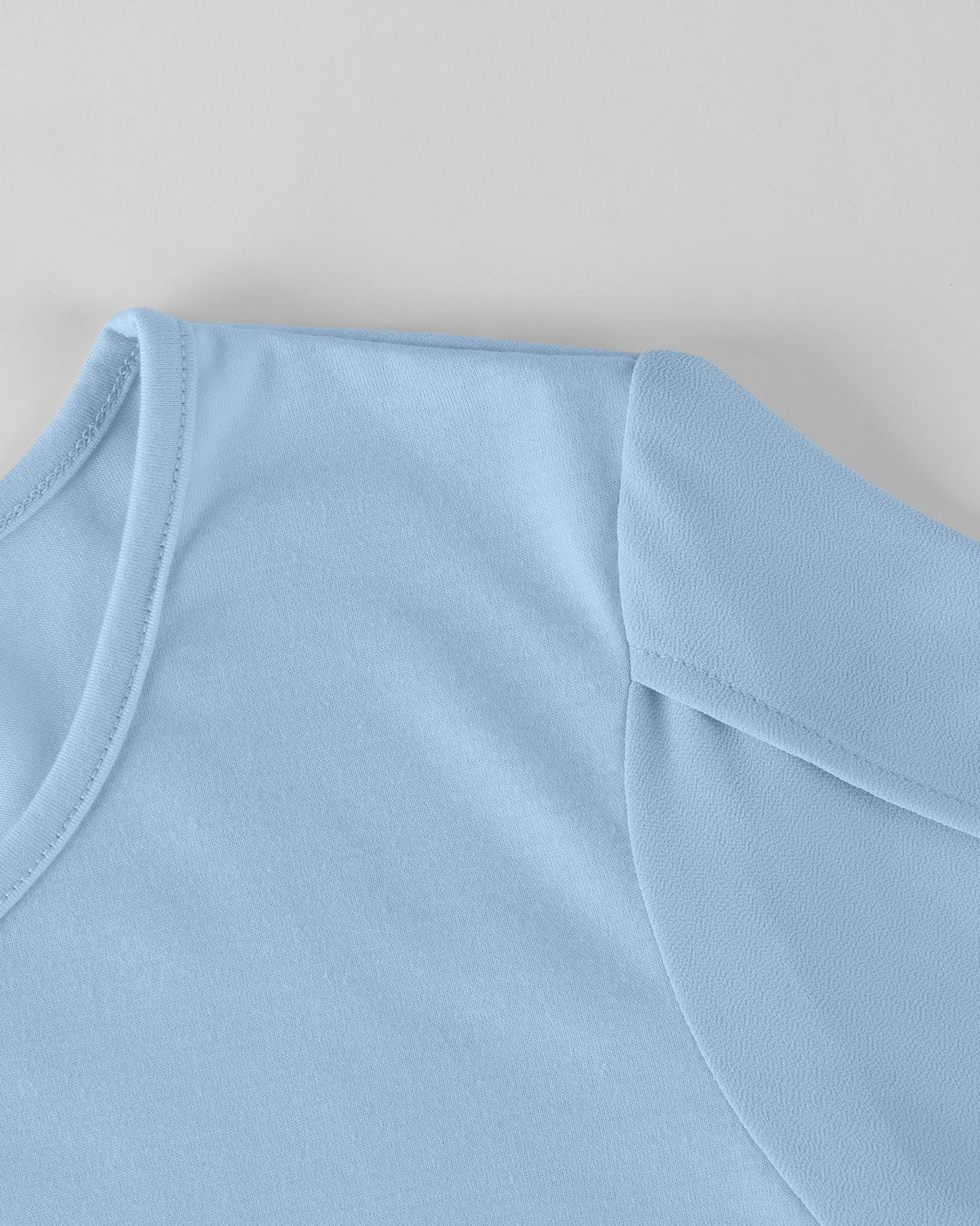 Close-up of a light blue sleeveless top on a neutral background