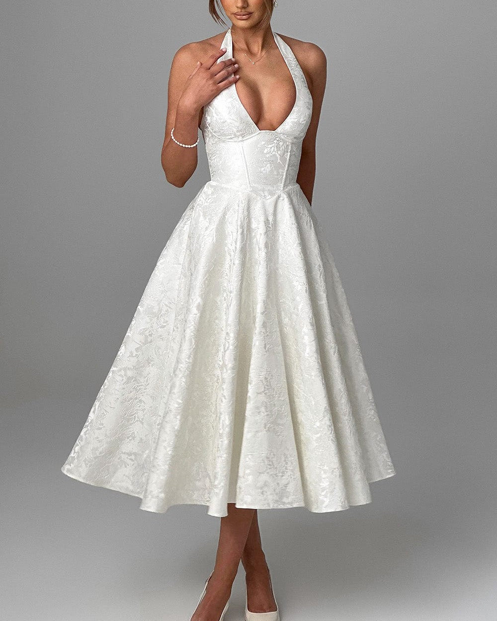 Woman wearing a white lace dress on a gray background