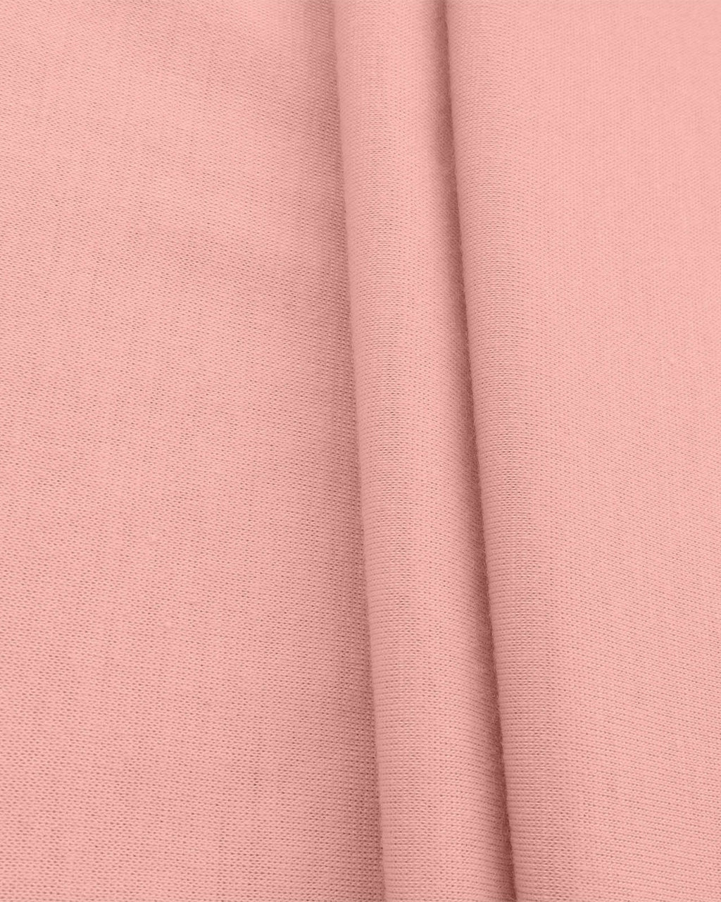 A close-up of dusty pink fabric with a visible woven texture and soft folds.