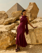 Woman in a burgundy dress standing in front of the pyramids