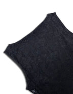 Close-up of a black lace garment, showing the detailed floral lace pattern and scalloped edge against a plain white background.