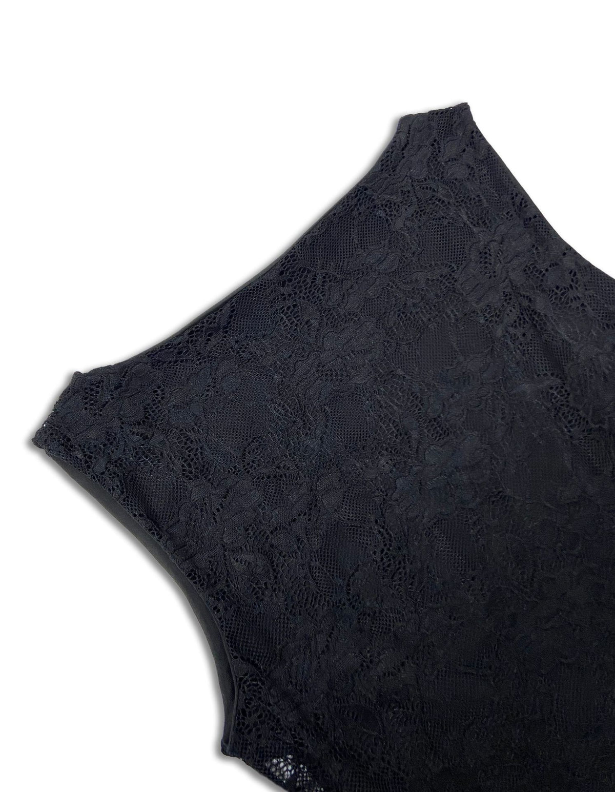 Close-up of a black lace garment, showing the detailed floral lace pattern and scalloped edge against a plain white background.