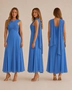 Three views of a woman modeling a flowing blue maxi dress against a plain beige studio background. The dress has a draped wrap-style bodice, sleeveless cut, and a loose back drape.