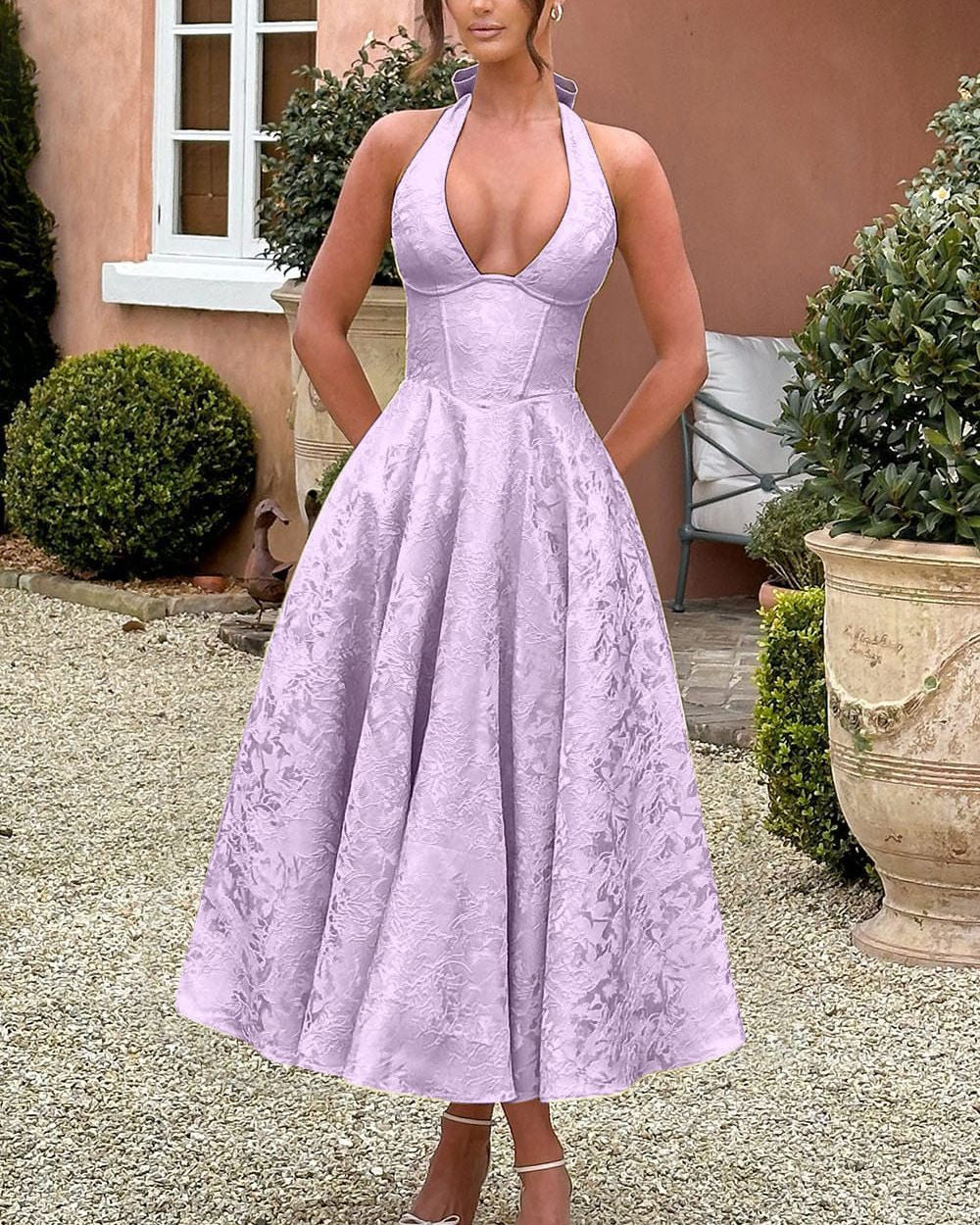 Woman wearing a lavender lace dress standing outdoors.