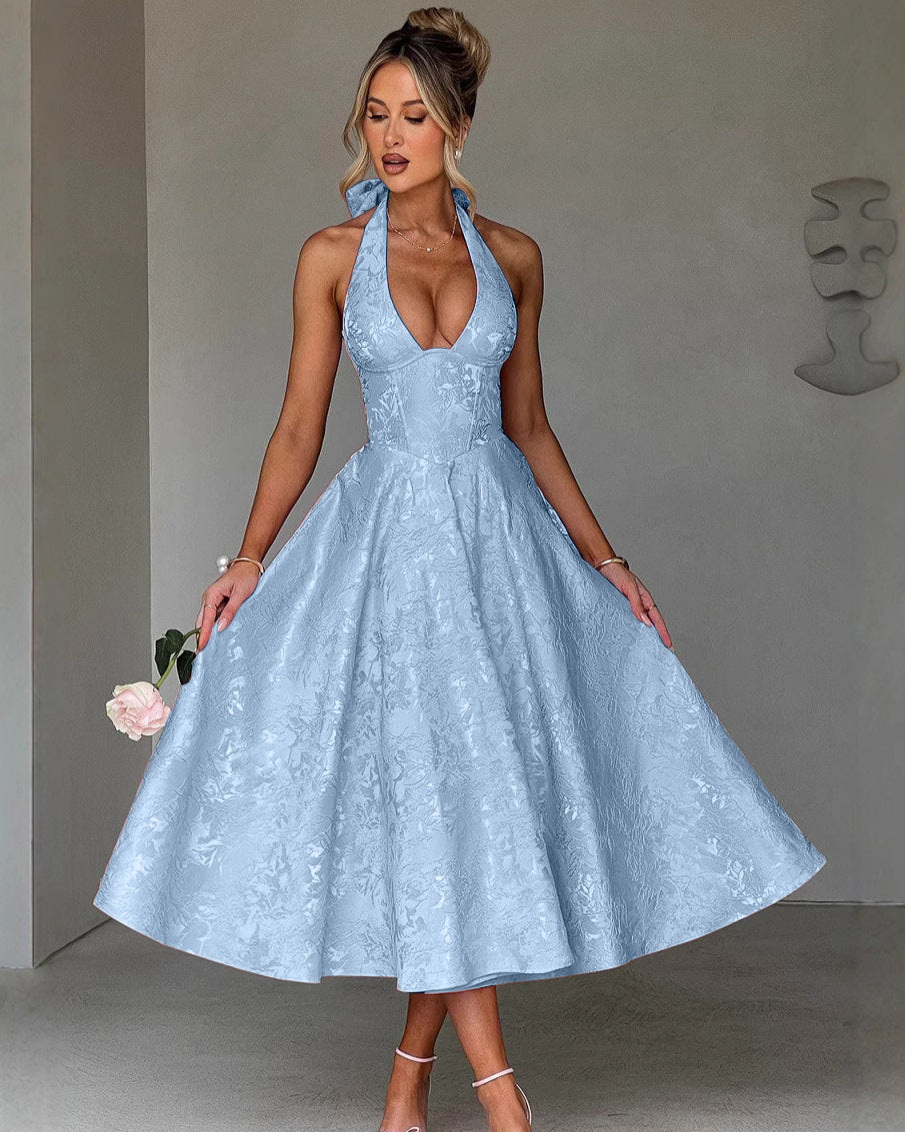 Woman wearing a light blue lace dress against a gray background